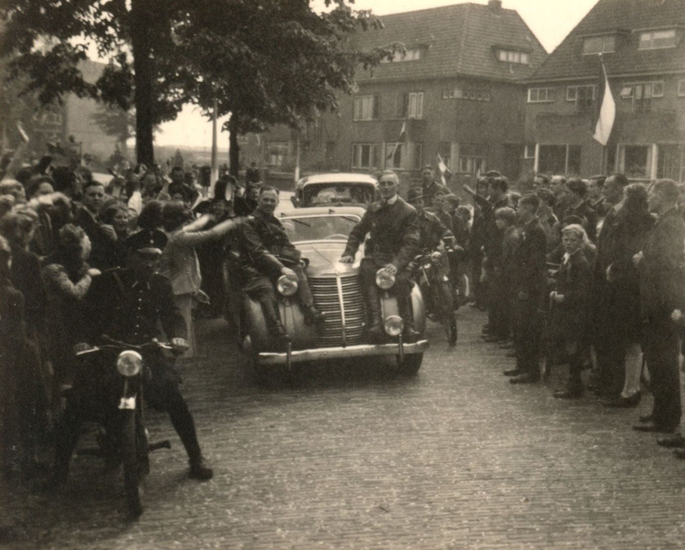 Hier rijden verzetsleiders Piet Doelman (links) en Piet van der Hoeven (rechts) tijdens de optocht via de Schiedamseweg richting het Emmaplein.